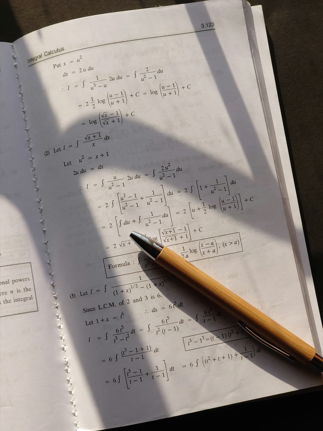 A pencil resting on a notebook page of math problems